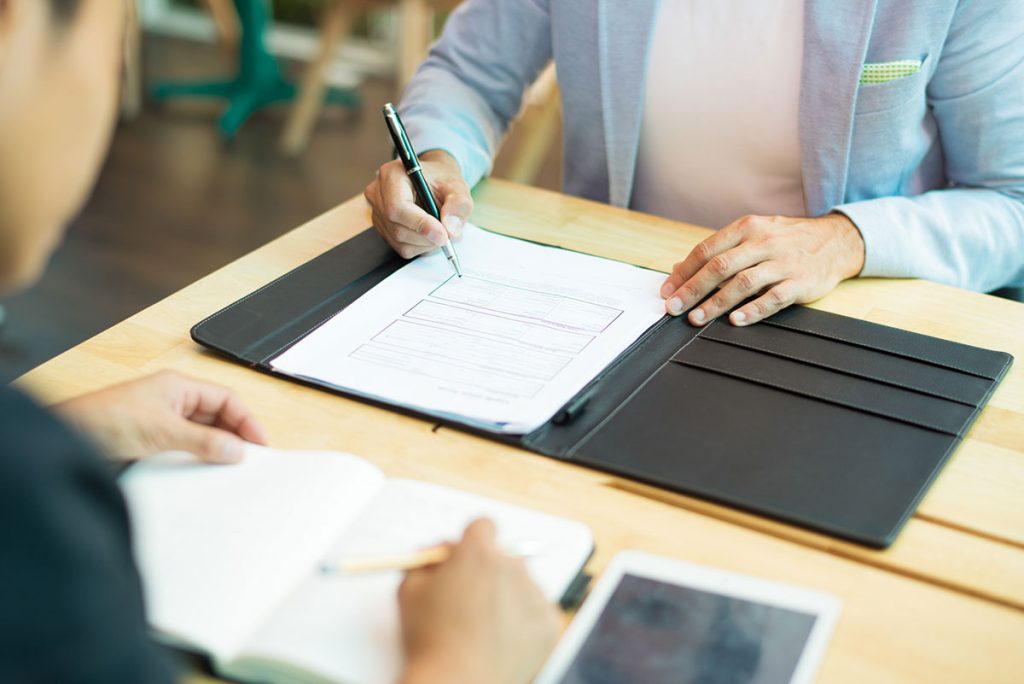 Close up businessman sitting table filling document