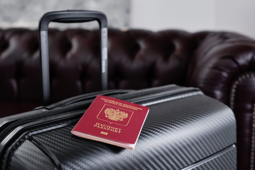 Russian passport on a black travel suitcase, selective focus. emigration of russians from the country, problems with visas, refugees