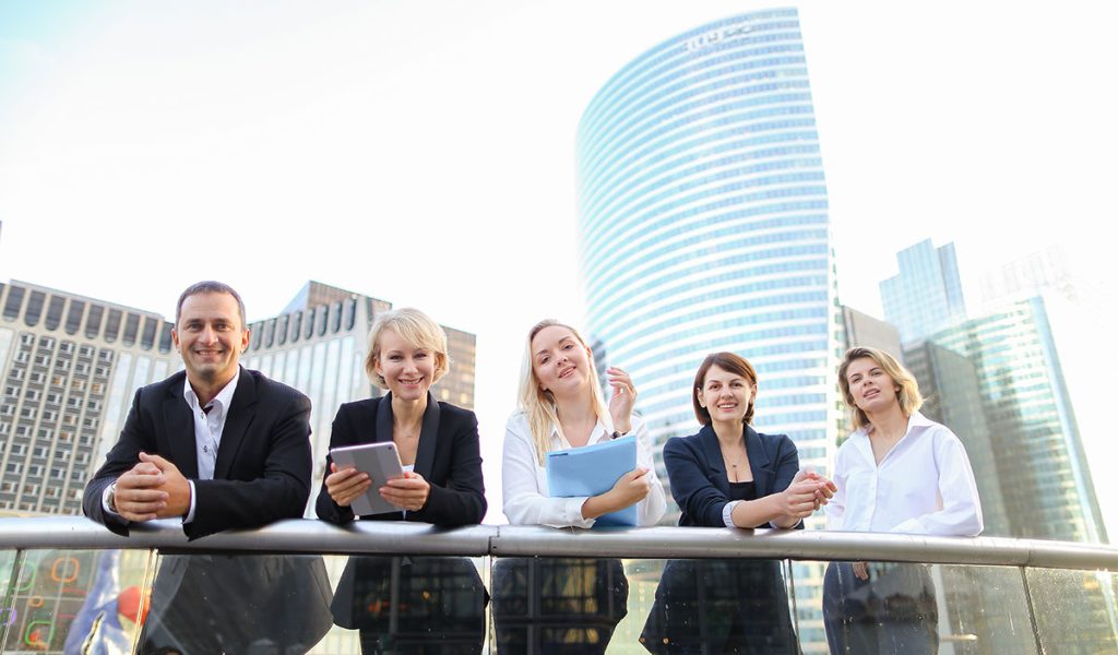 Satisfied business team members speaking outdoors